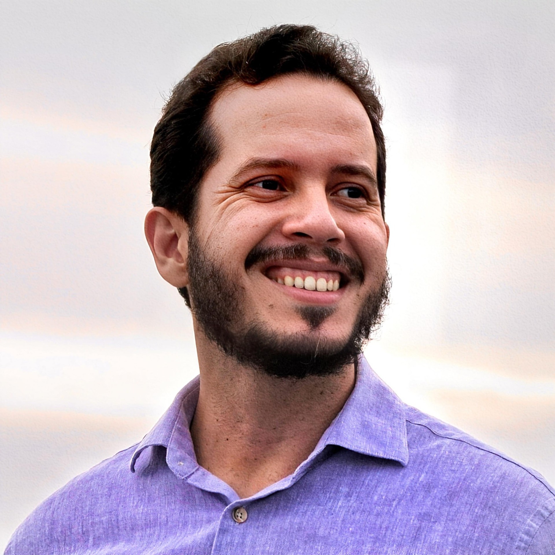 André Carvalho sorrindo, vestindo camisa lilás
